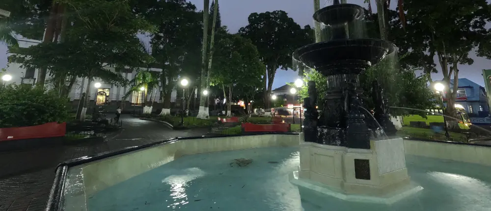 Fontaine éclairée dans un parc du centre d'Alajuela, à la tombée de la nuit