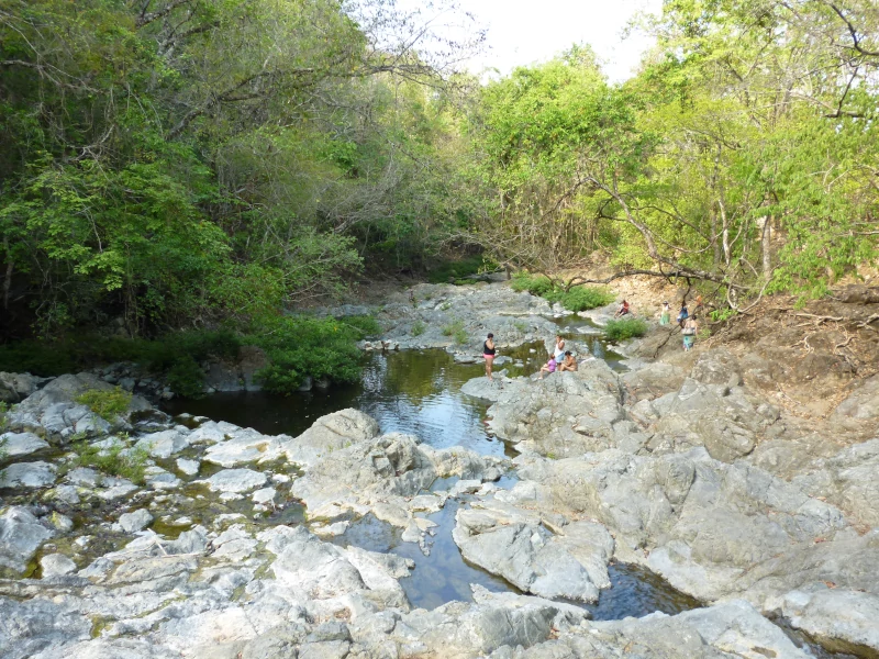 Lit rocheux du río Montezuma et ses bassins sur le chemin de la cascade, avec des baigneurs
